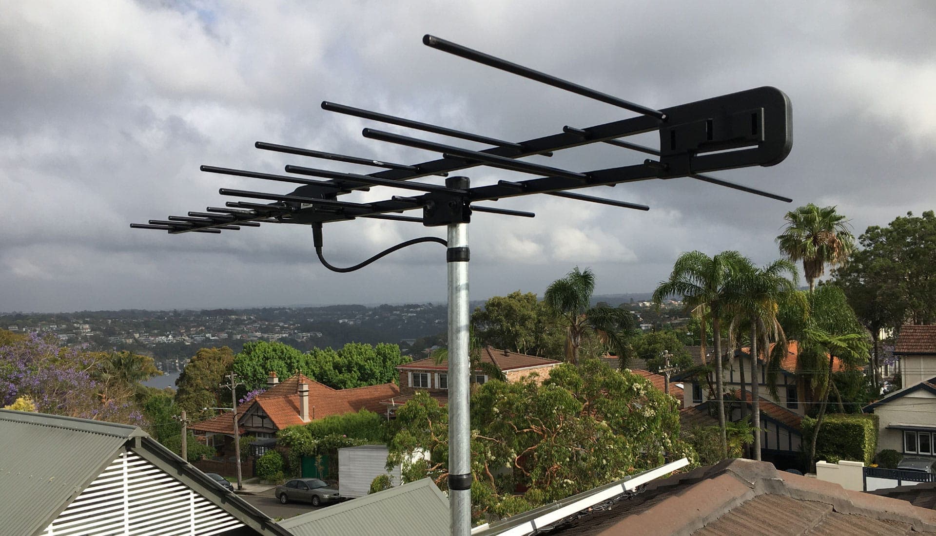 Rooftop TV antenna above Sydney homes, the type we diagnose, repair and add extra points from