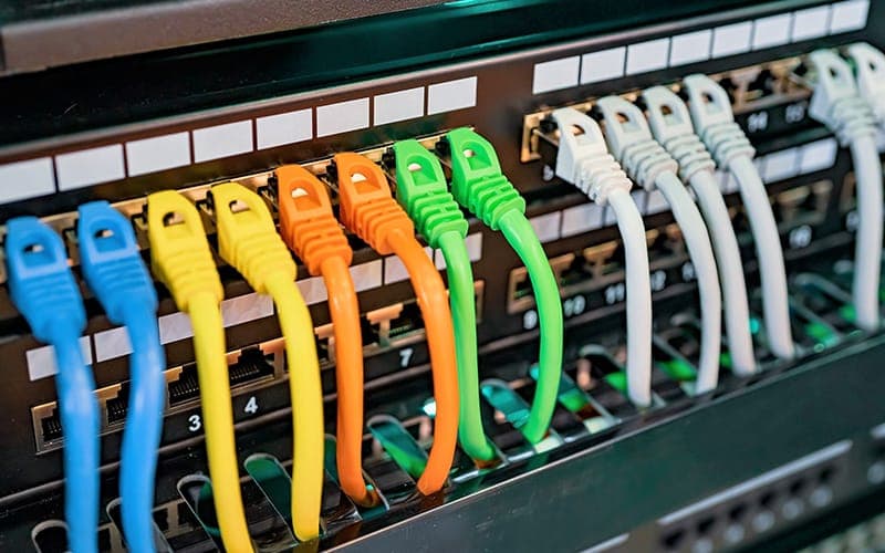 Colour-coded patch leads plugged into a numbered network patch panel