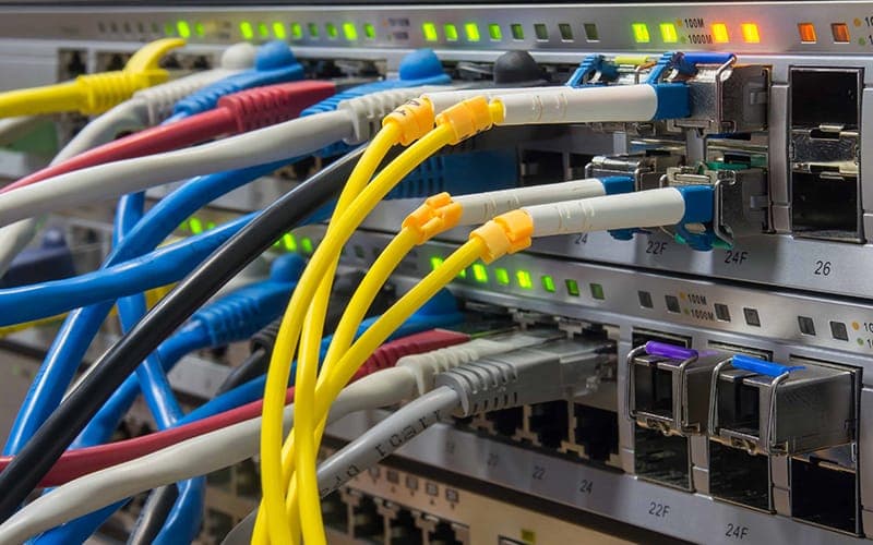 Network switch with mixed-colour patch leads and fibre uplinks