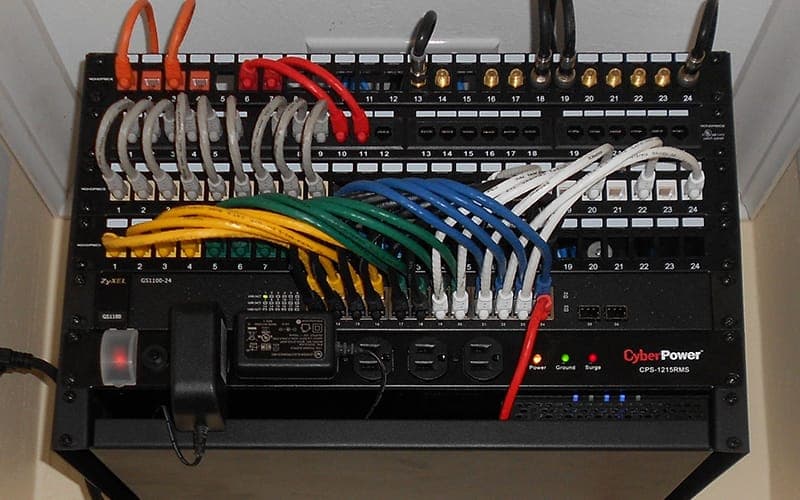 Home network cabinet with a patch panel, colour-coded leads and a UPS mounted below
