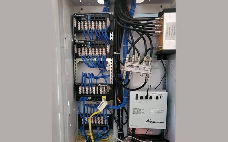 Wall-mounted network enclosure with Cat6 punch-down blocks and a smart home hub
