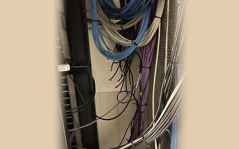 Structured cabling bundled and dressed into a wall-mounted network cabinet