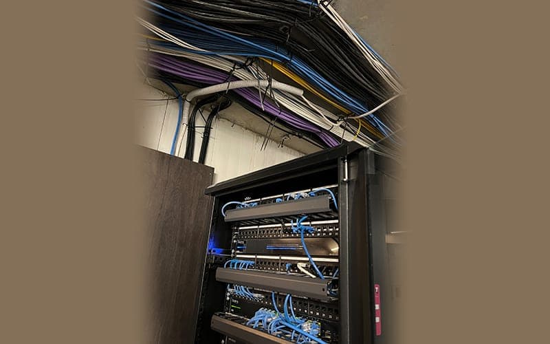 Open network cabinet with Cat6 cabling dressed into the patch panel