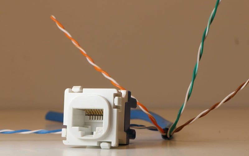 Cat6 keystone jack with the cable pairs untwisted ready for punch-down