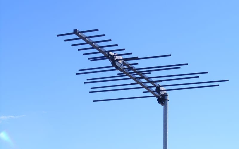 Log-periodic digital TV antenna on a mast against a blue sky