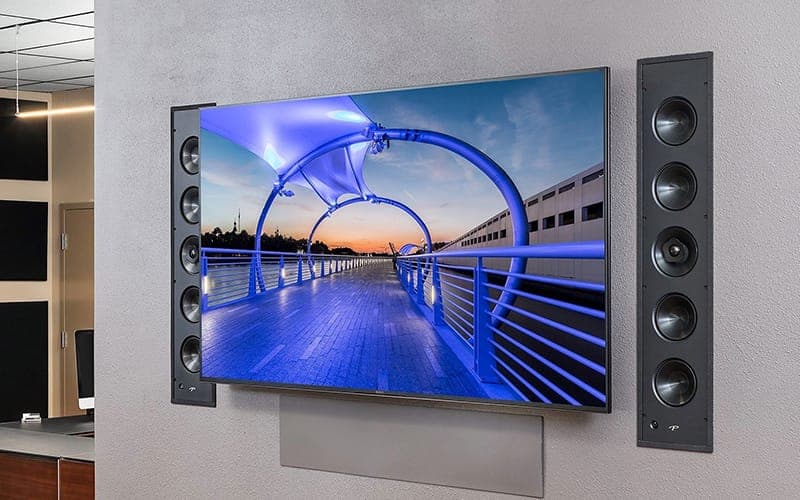 Wall-mounted TV flanked by two in-wall column speakers