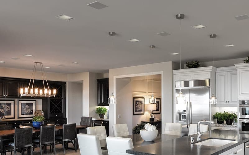 Open-plan kitchen and dining area with in-ceiling speakers installed flush into the ceiling