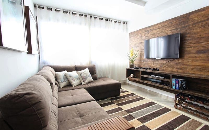 TV mounted on a timber-panelled feature wall above a floating media unit