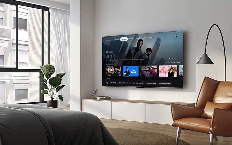 TV wall mounted above a white floating cabinet in an apartment bedroom
