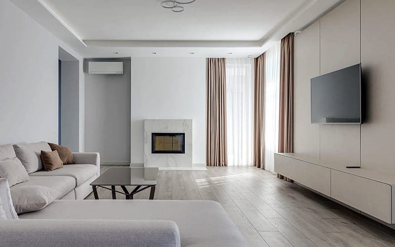 TV wall mounted on a panelled wall beside a fireplace in a formal living room