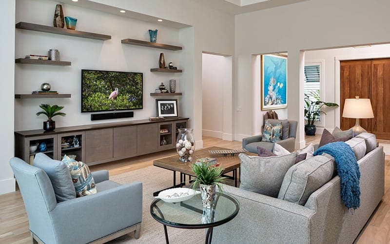TV above a media unit between floating timber shelves with a soundbar beneath