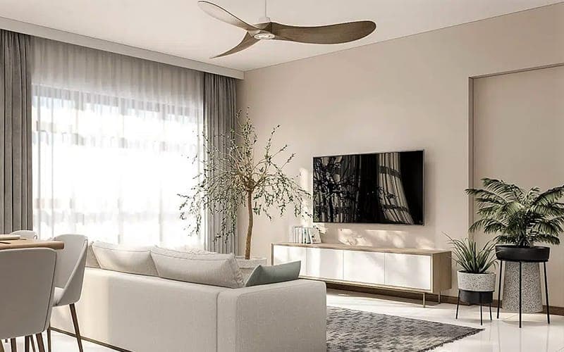 TV wall mounted above a white console in a living room with a ceiling fan